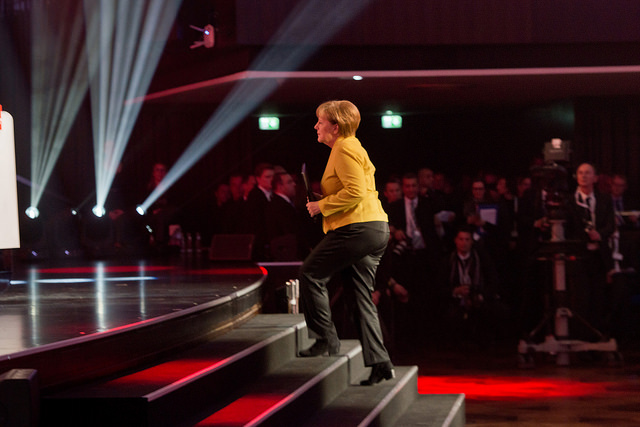 German Chancellor walking up a stage